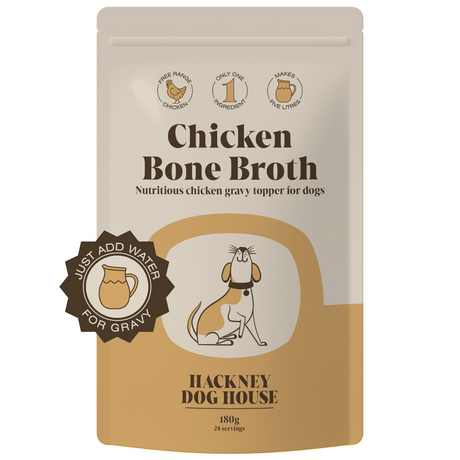 A pouch of chicken bone broth powder for dogs next to a bowl of warm, whisked broth, highlighting its use as a nutritious drink or food topper.